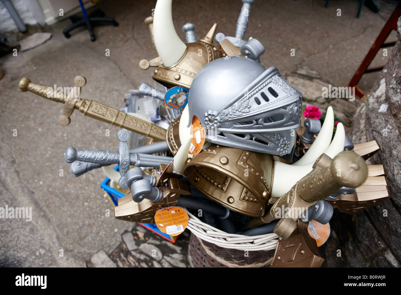 A bucket full of plastic swords and knights suits of armour Stock Photo