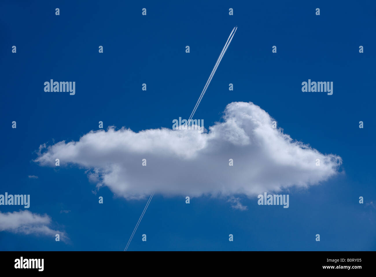 trace of the aircraft in the blue skies through a cloud Stock Photo