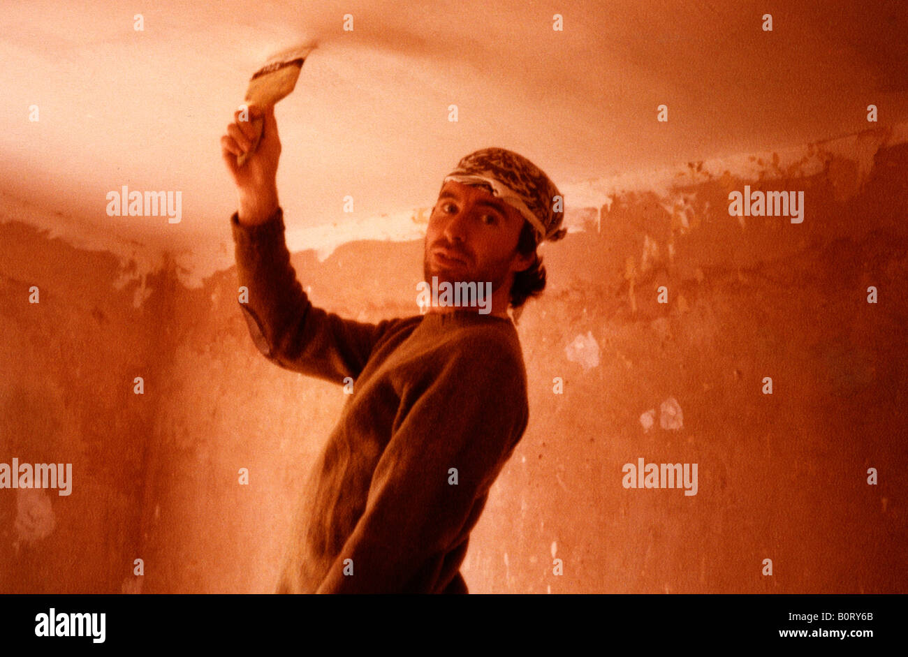 Diy Guy Man Painting A Ceiling Wearing Head Scarf Stock Photo