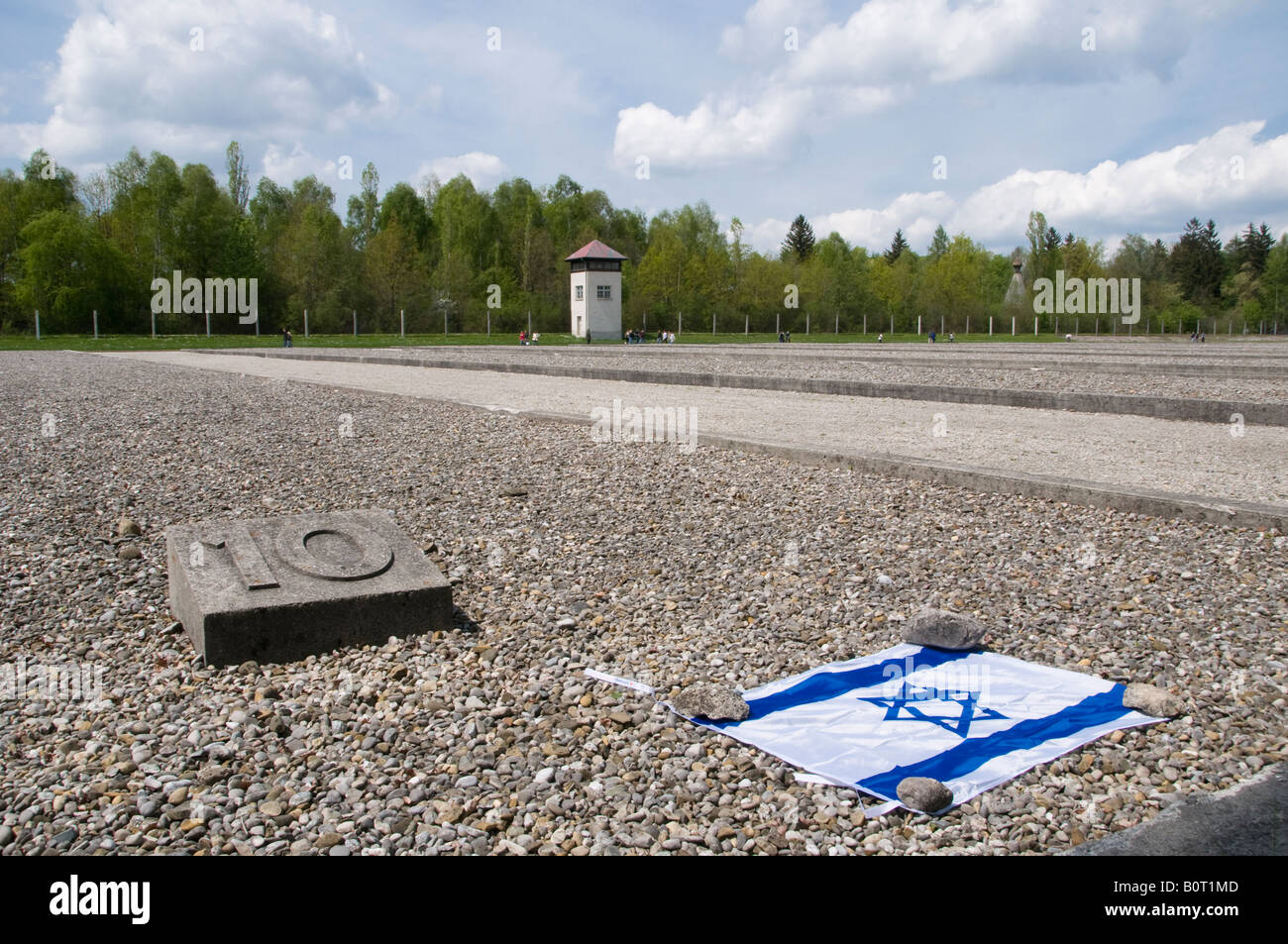 Israeli flag with a marker where prisoners barrack building #10 stood in Dachau concentration camp, Bavaria, Germany Stock Photo