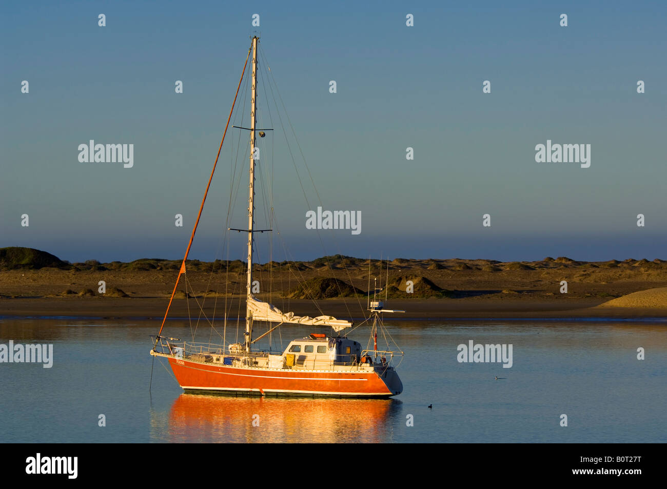 Sailboat anchored in the still calm water of Morro Bay California Stock