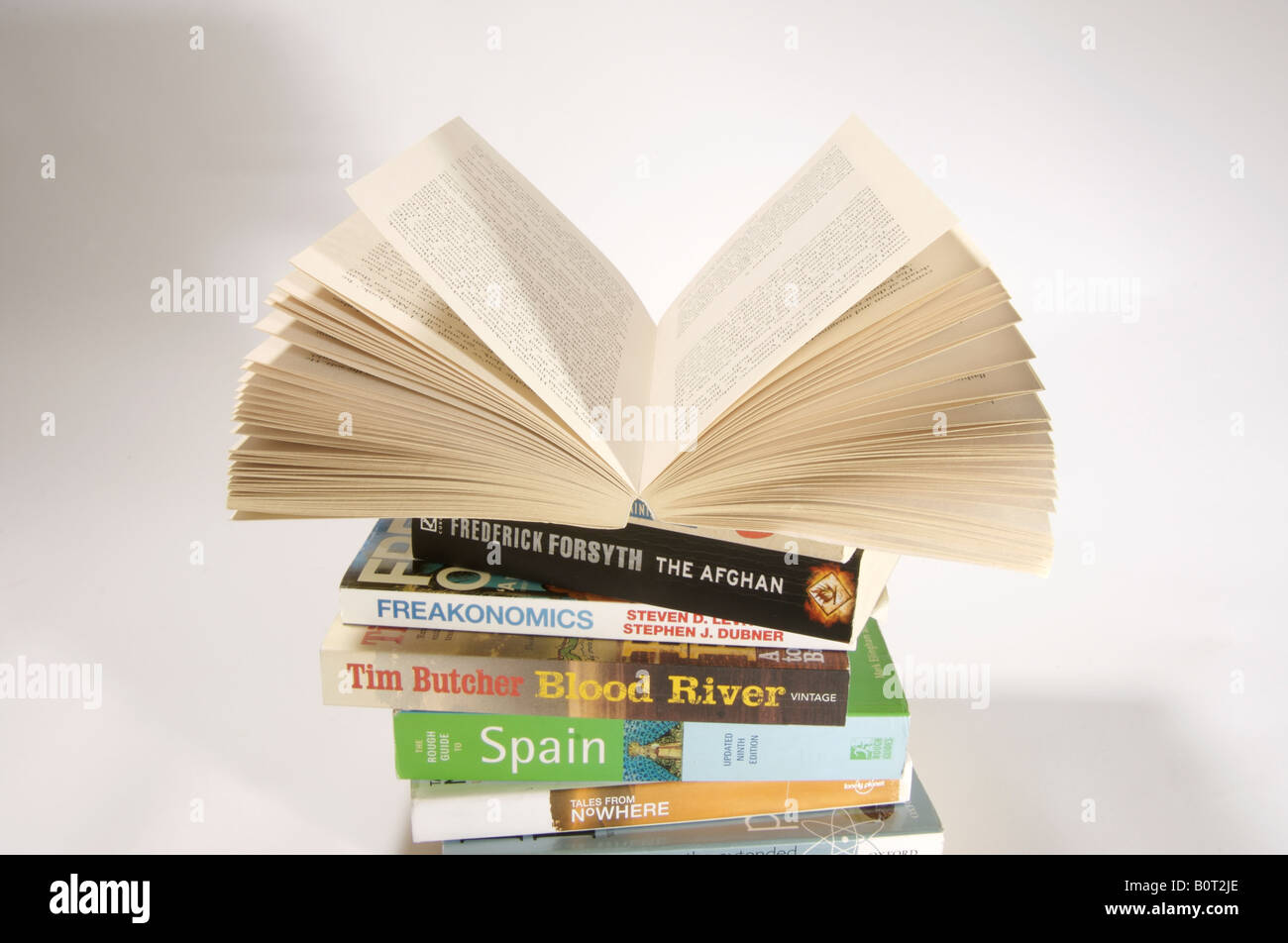 Pile of paperback books. Open book on top. Stock Photo