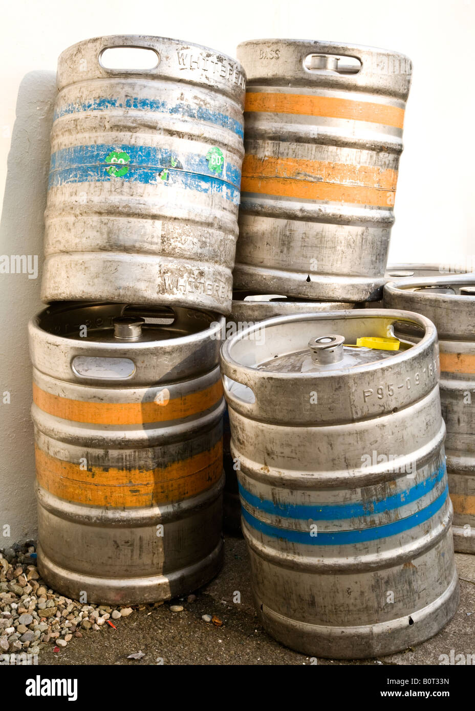Empty metal beer kegs stacked outside a pub awaiting collection Stock