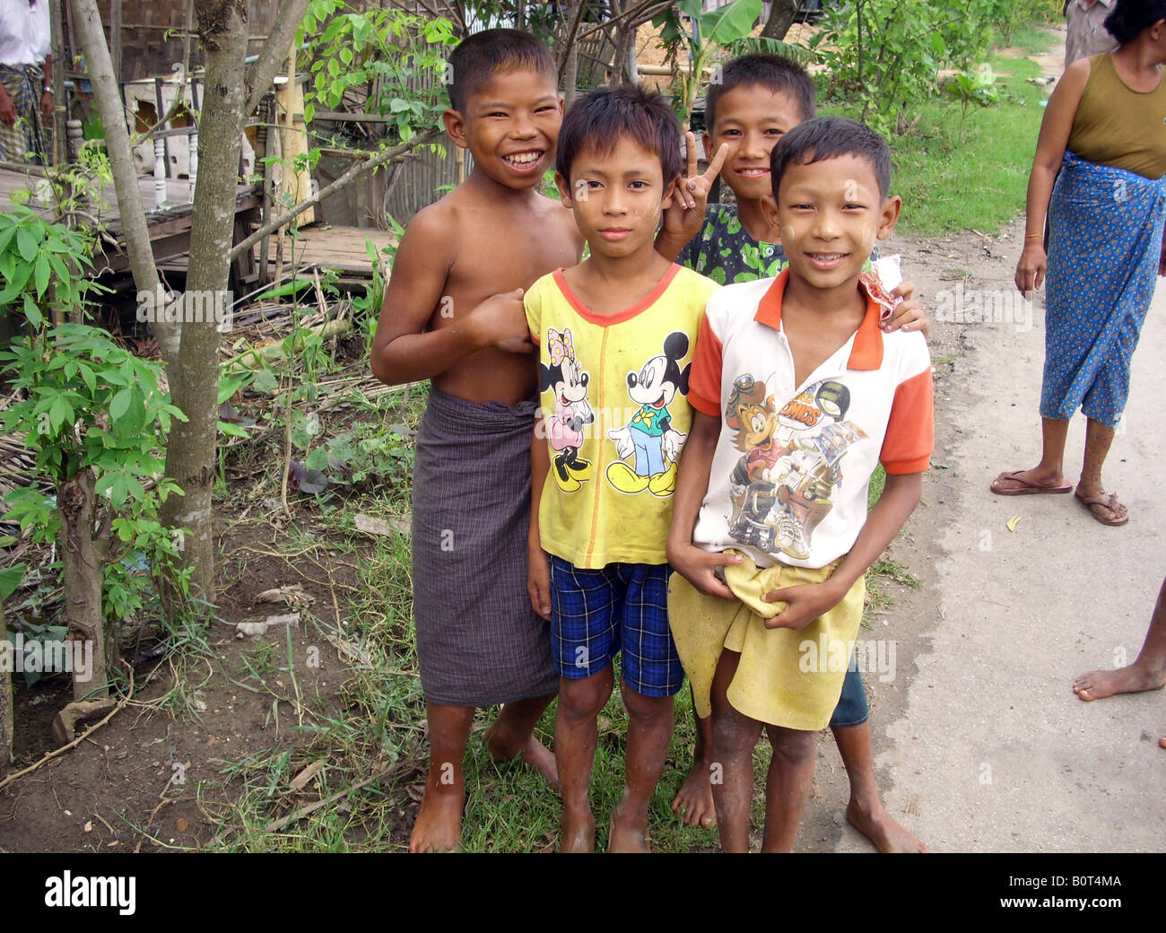 Four Burmese children smile through adversity after the huge storm Cyclone Nargis ripped through their village south of Rangoon. Stock Photo