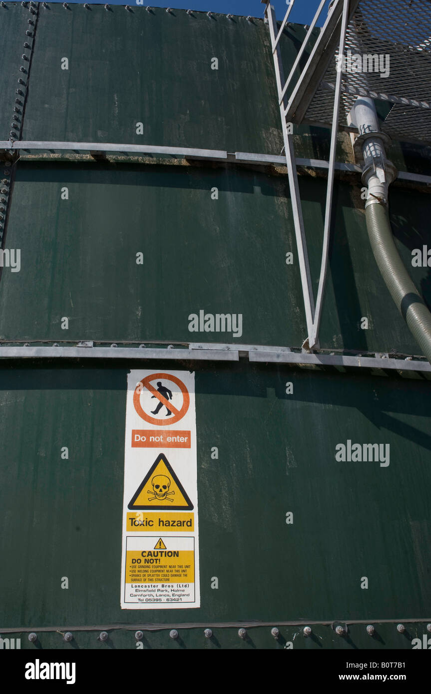 Warning signs on the side of a slurry storage tower Cumbria England