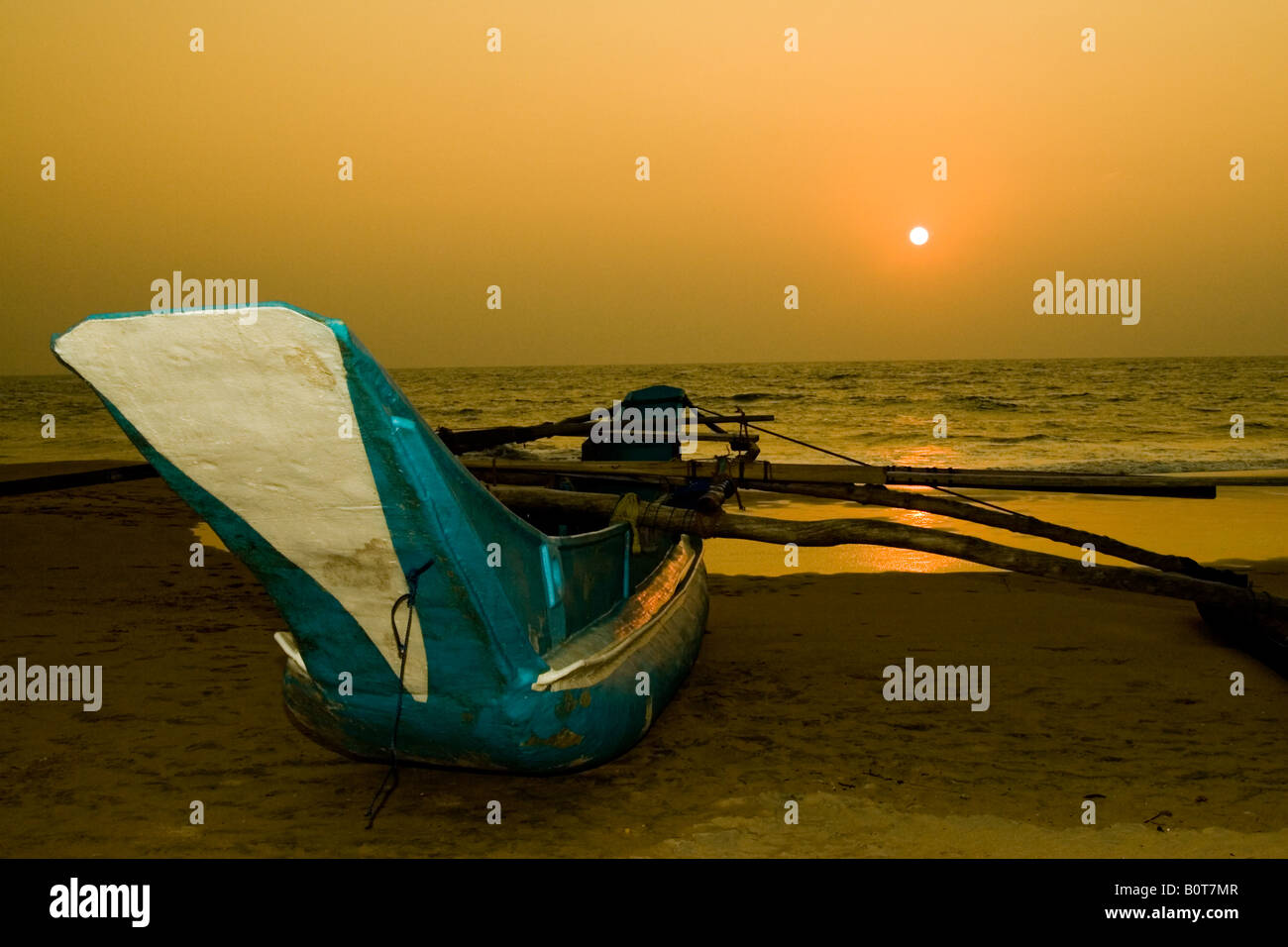 Outriger on beach in Sri Lanka at sunset Stock Photo