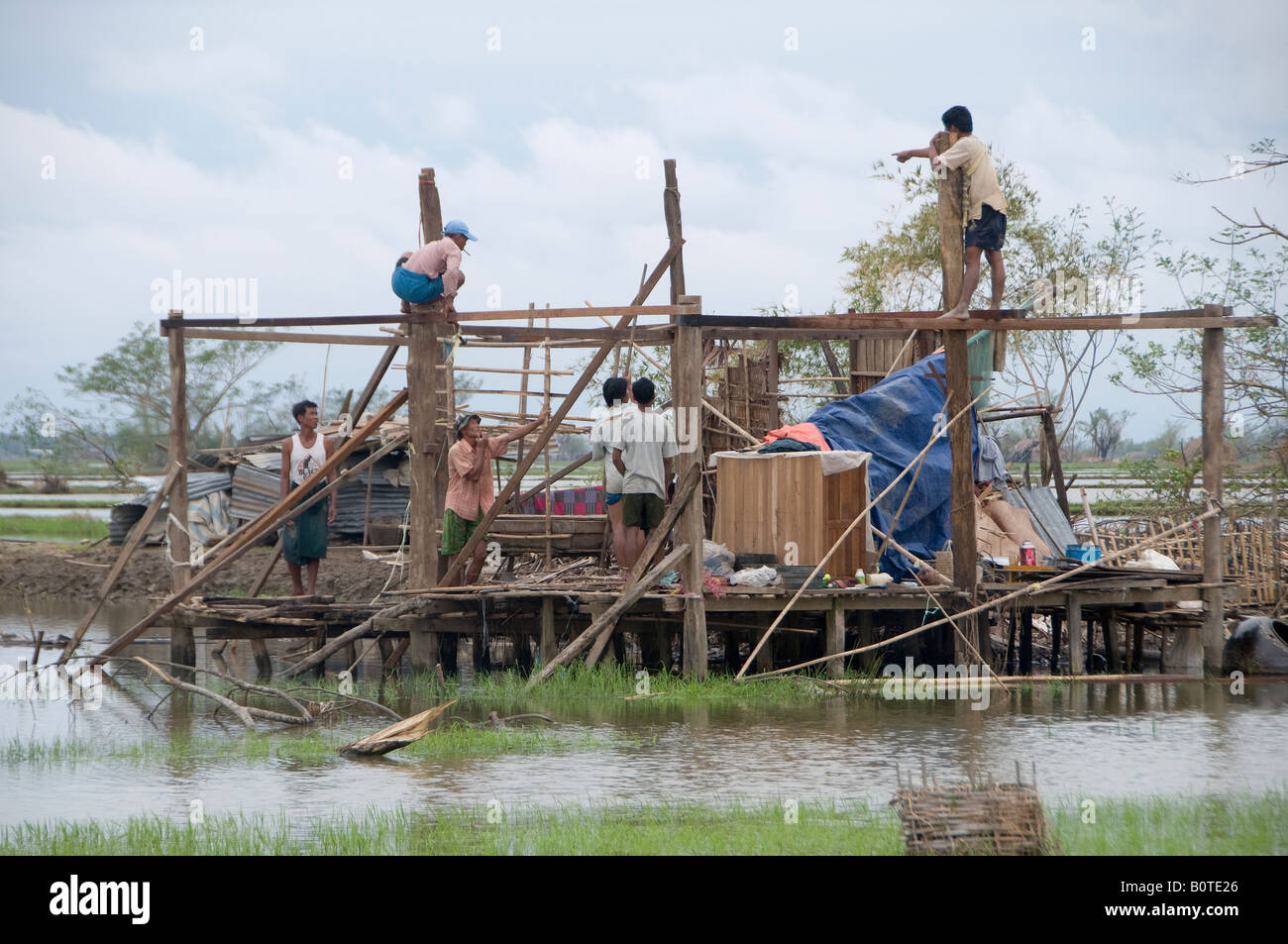 Cyclone Nargis survivors rebuilding a house in a flooded rural area near the city of Yangon Republic of the Union of Myanmar Stock Photo