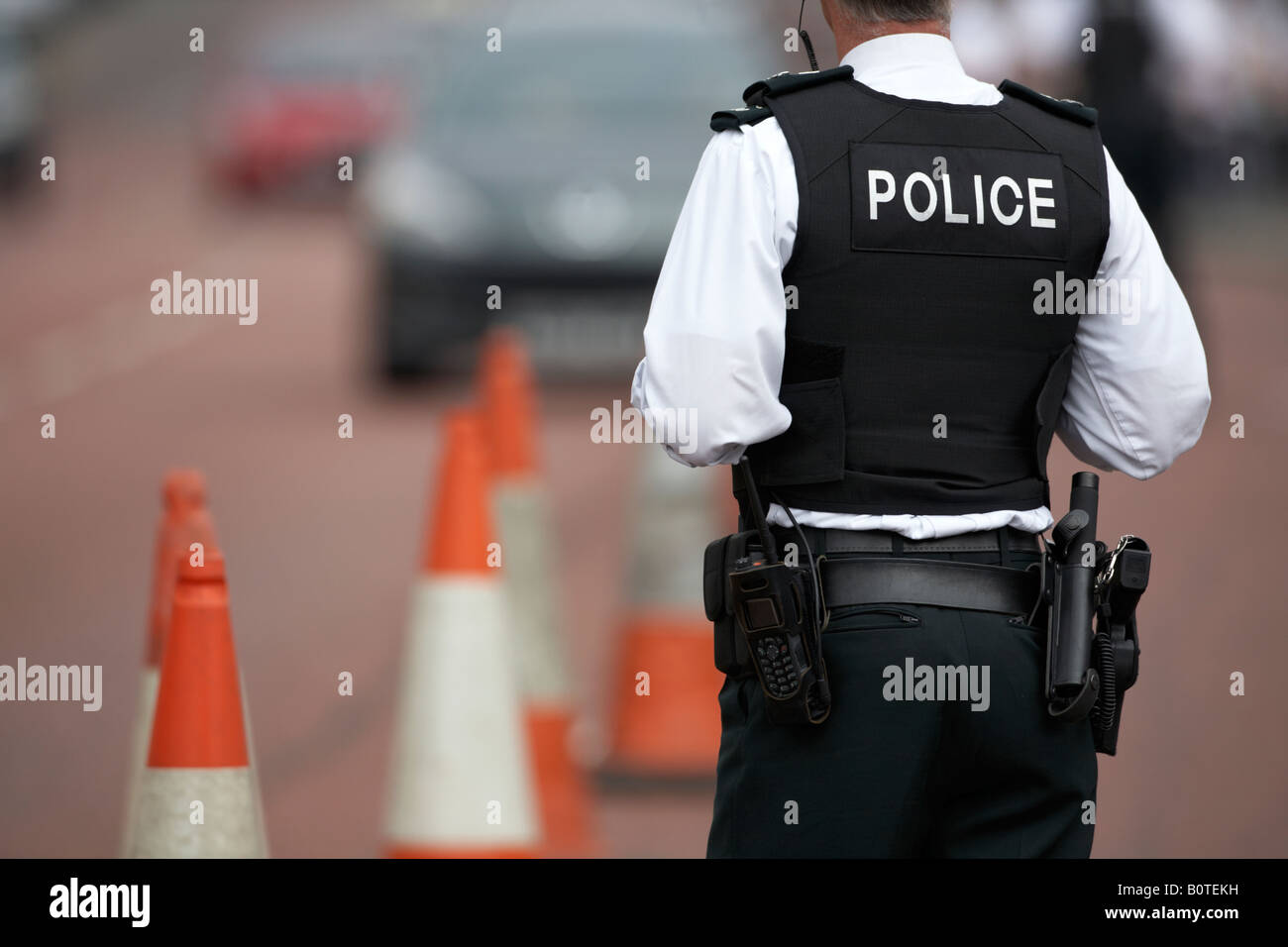 PSNI police service northern ireland officer sergeant standing watching traffic in coned off roadside area Stock Photo