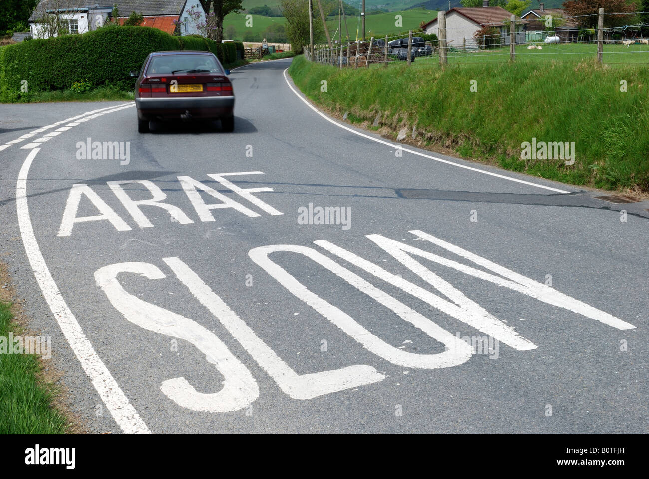 Slow Down Araf Road Sign In Welsh And English With Car In Background Stock Photo Alamy