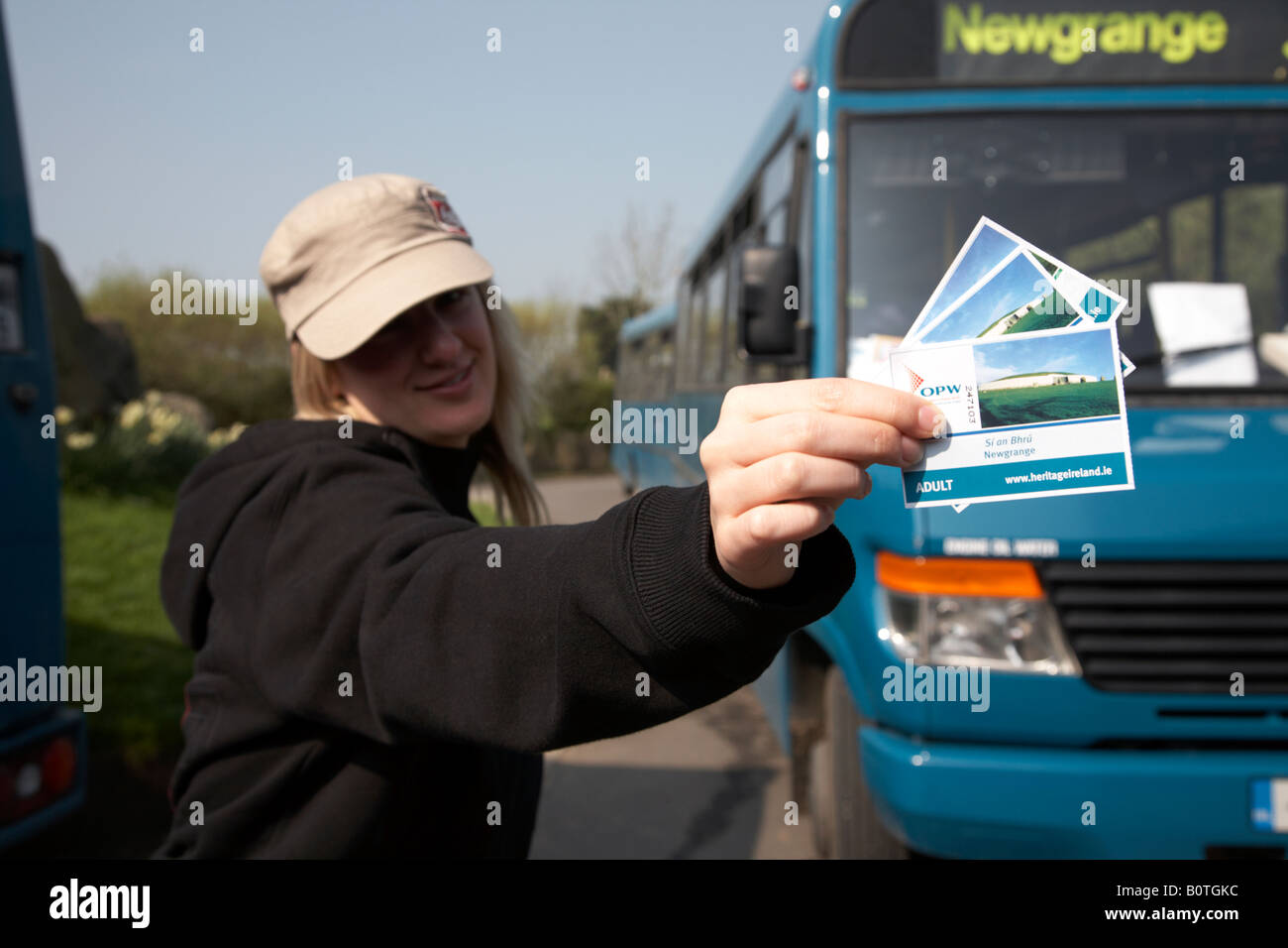 female tourist holding tickets to Si an Bhru newgrange and mercedes shuttle bus between the bru na boinne visitors centre Stock Photo