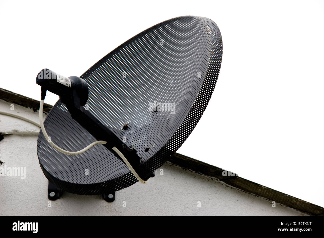Television satellite receiver dish fitted to the wall of a house Stock Photo