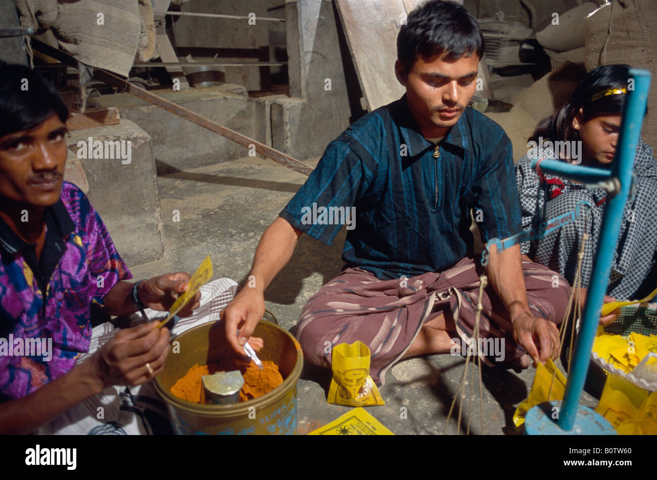 Working in a chili milling and grinding room making powder from chilis for export rural Bangladesh Stock Photo