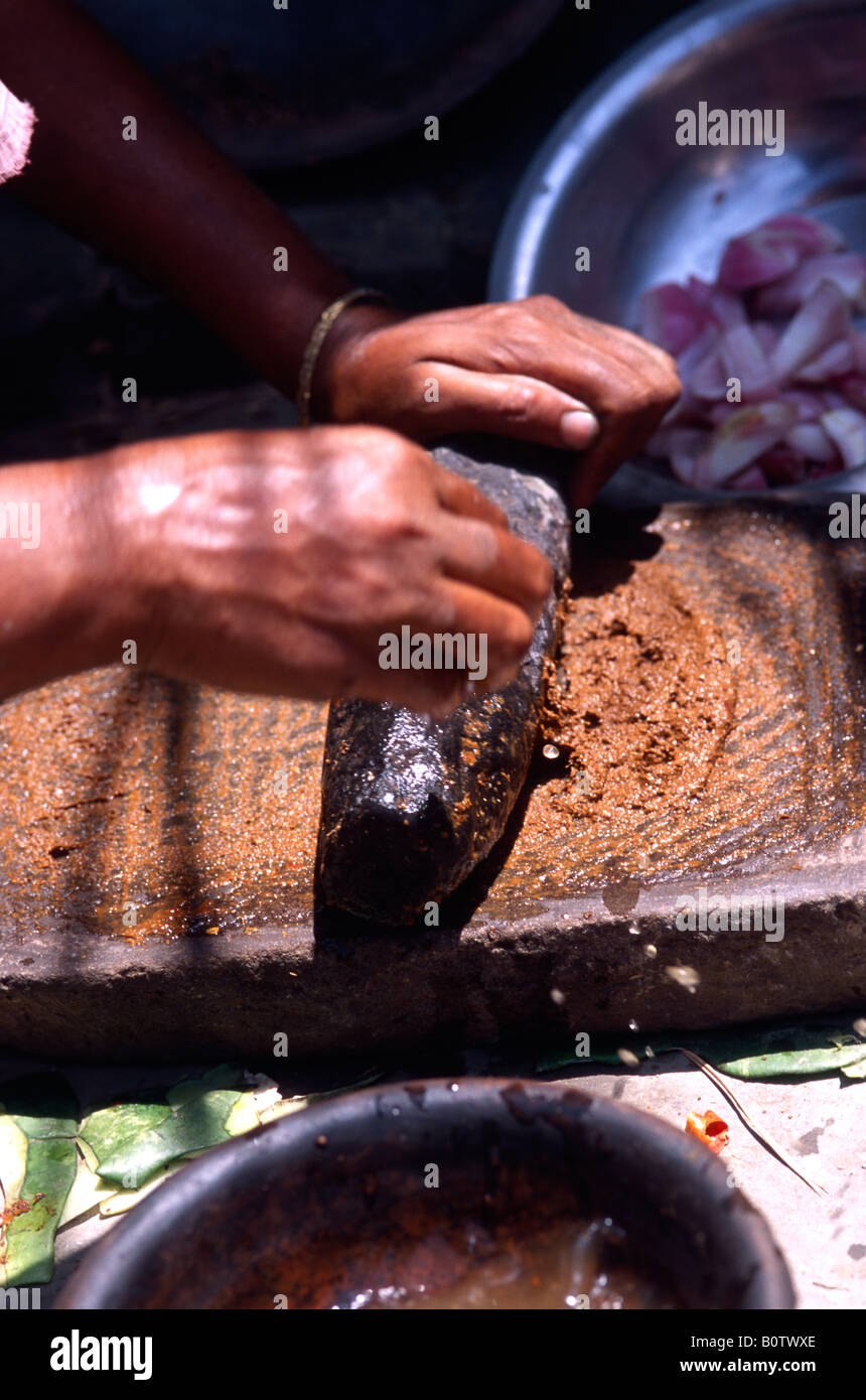 Grinding chilis to a paste for cooking Bangladesh Stock Photo