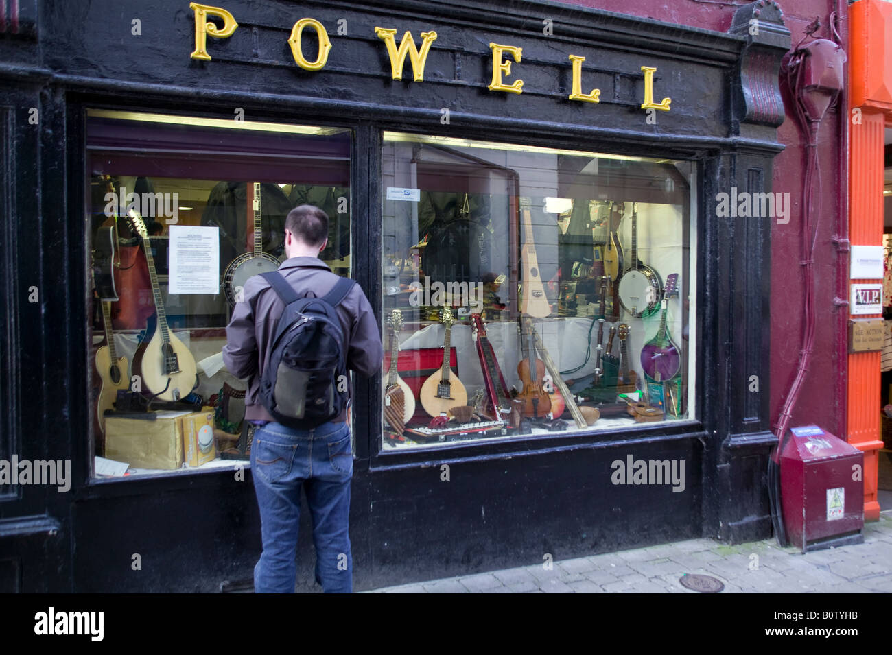 A man looking at guitars in a window in Galway Stock Photo