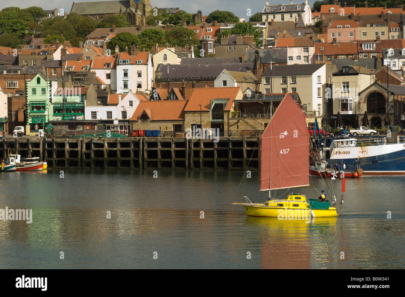 Junk rigged yacht departing from Scarborough old town harbour, North Yorkshire, UK Stock Photo