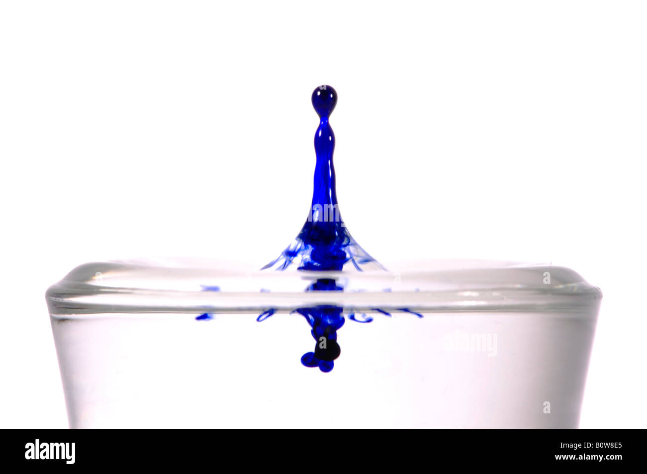 Drop of ink falling into a glass of water Stock Photo