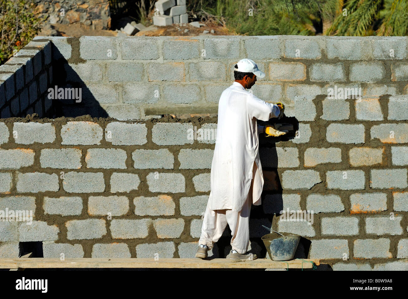 Bricklayer building a house in Misfah al-Ibriyeen, Oman, Middle East Stock Photo