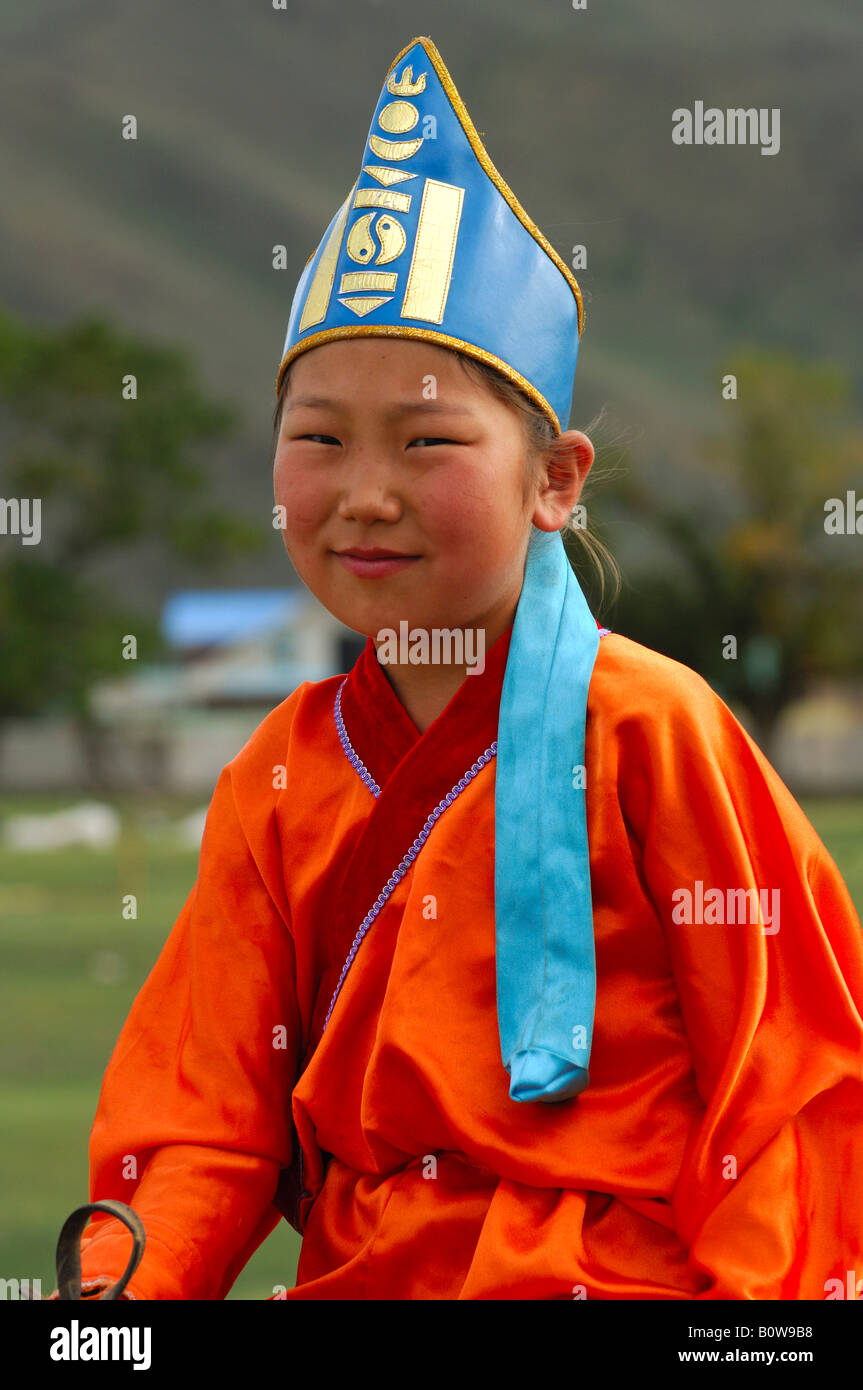 Ten-year-old girl wearing hat with soyombo emblem riding a horse, participant in the horsemanship competitions of the Naadam Fe Stock Photo