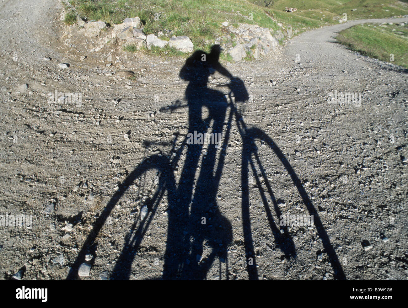 Cyclist's shadow on a gravel road Stock Photo