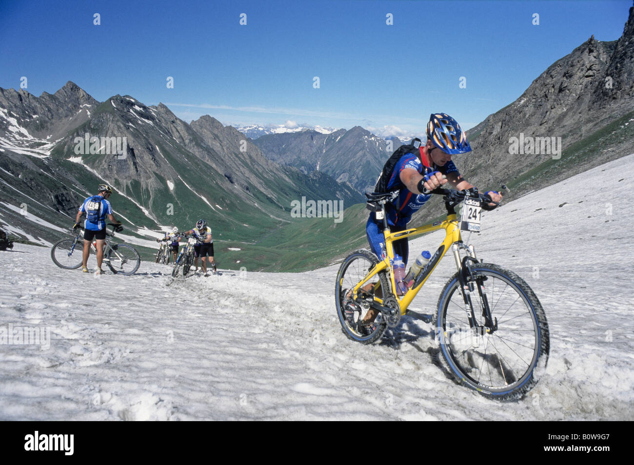 Mountain bike racers crossing a snow-covered mountain pass trail, Adidas  Bike Transalp Challenge, Pfunderer Joch, Bolzano-Bozen Stock Photo - Alamy