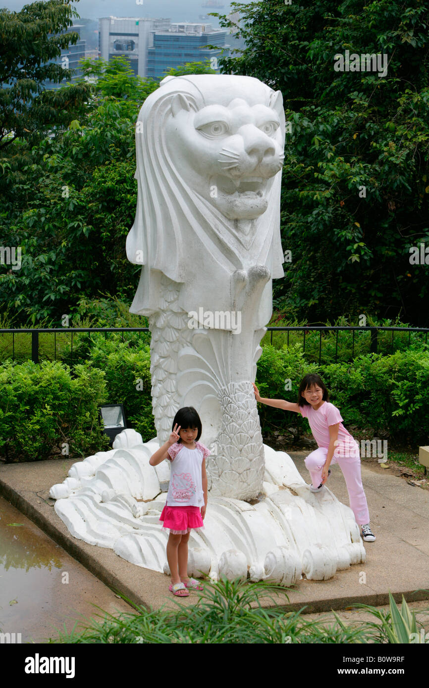 Girls playing around a statue of Merlion, emblem of Singapore, Singapore, Southeast Asia Stock Photo