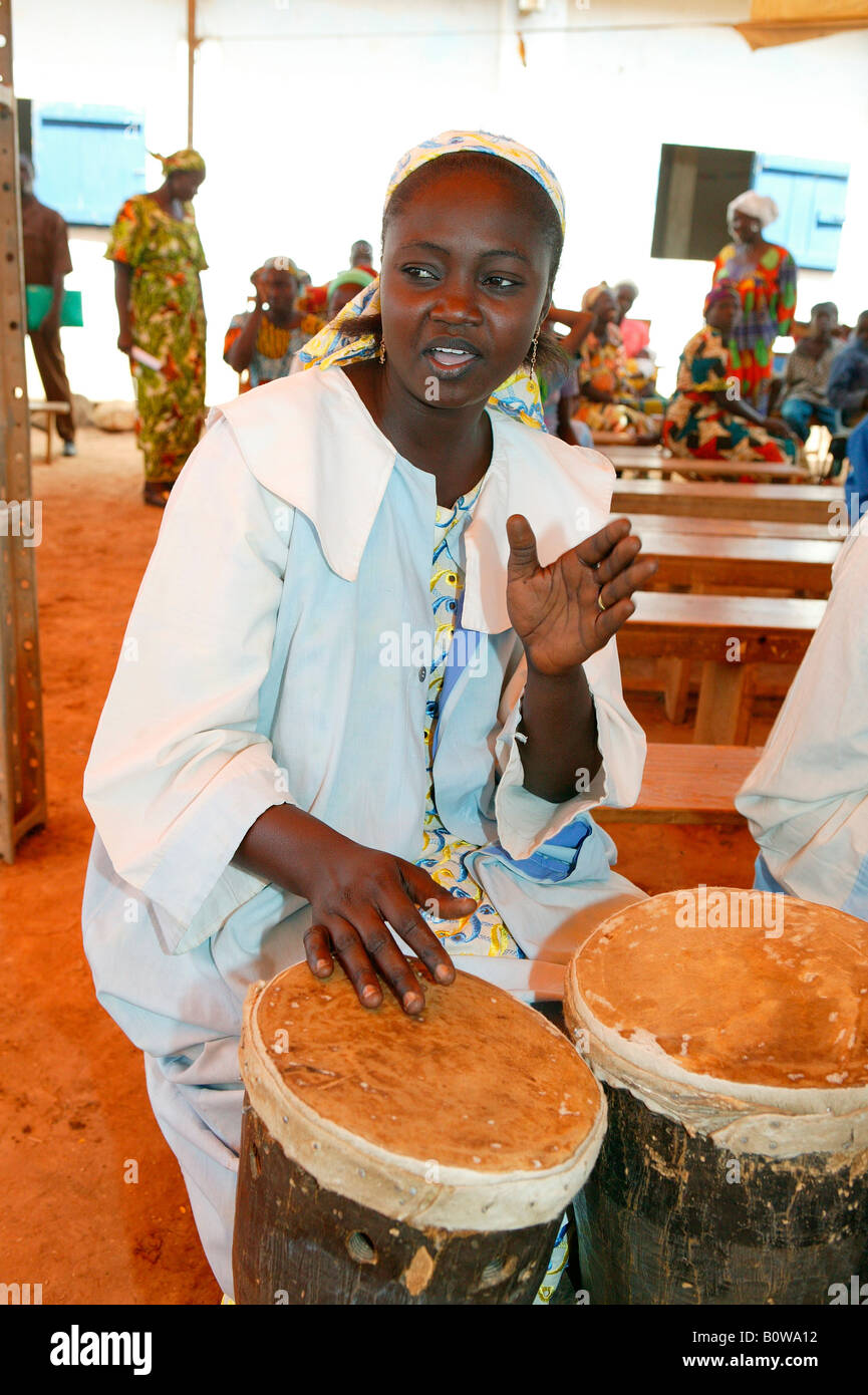 Woman playing drums at a church service, Garoua, Cameroon, Africa Stock Photo