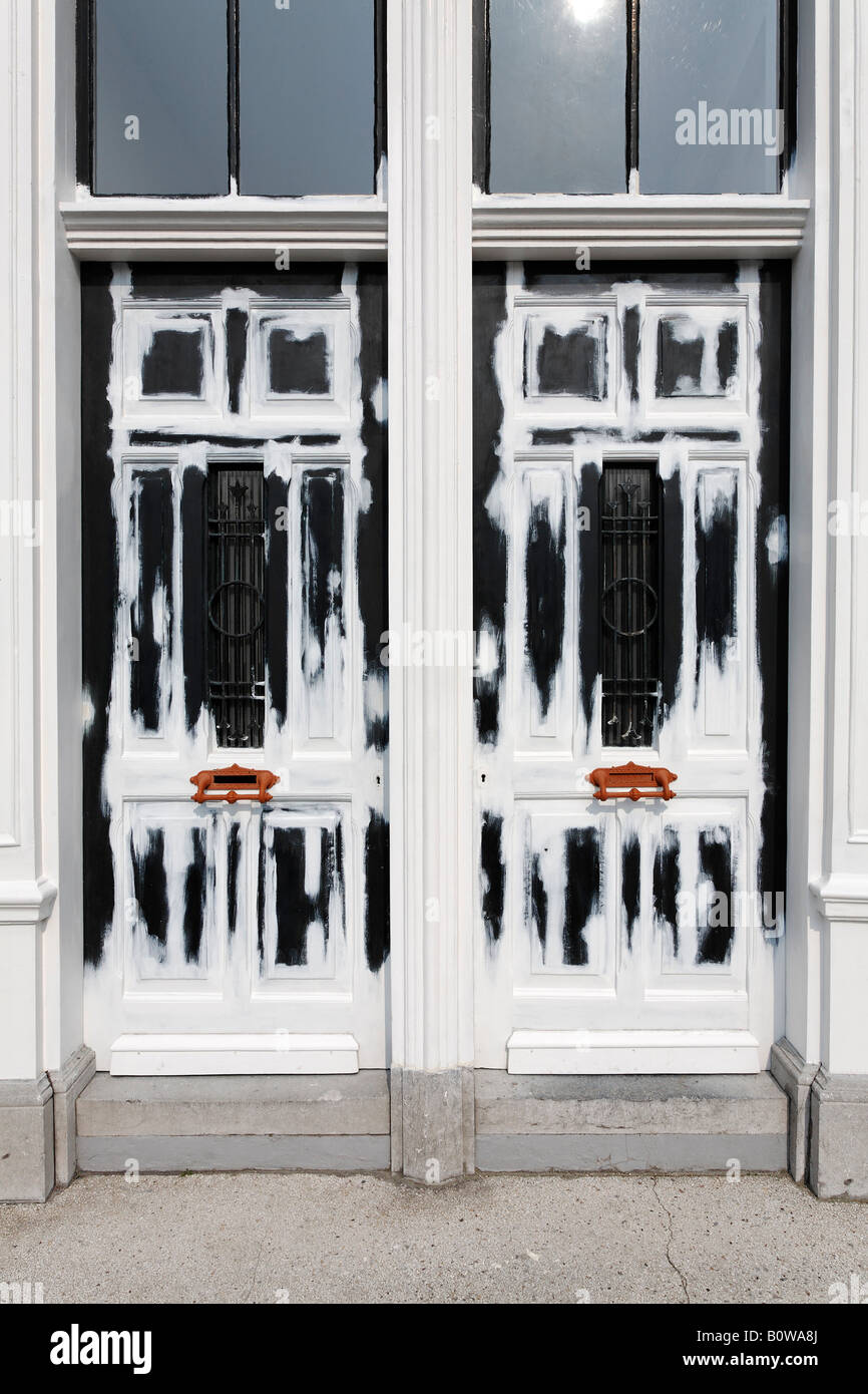 Old wooden building doors undergoing renovation, painted with white
