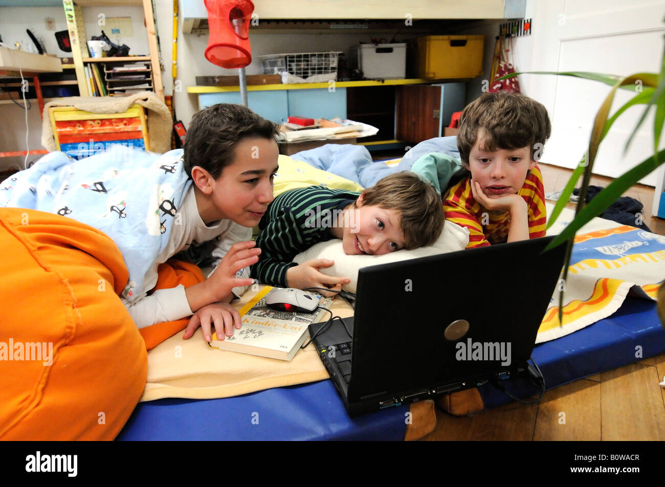 Three boys playing a computer game, laptop Stock Photo