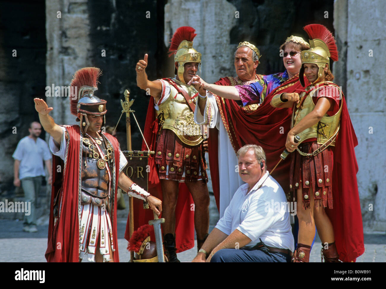 Tourists posing with costumed Roman legionaries being photographed at the Colosseum, Rome, Latium, Italy Stock Photo