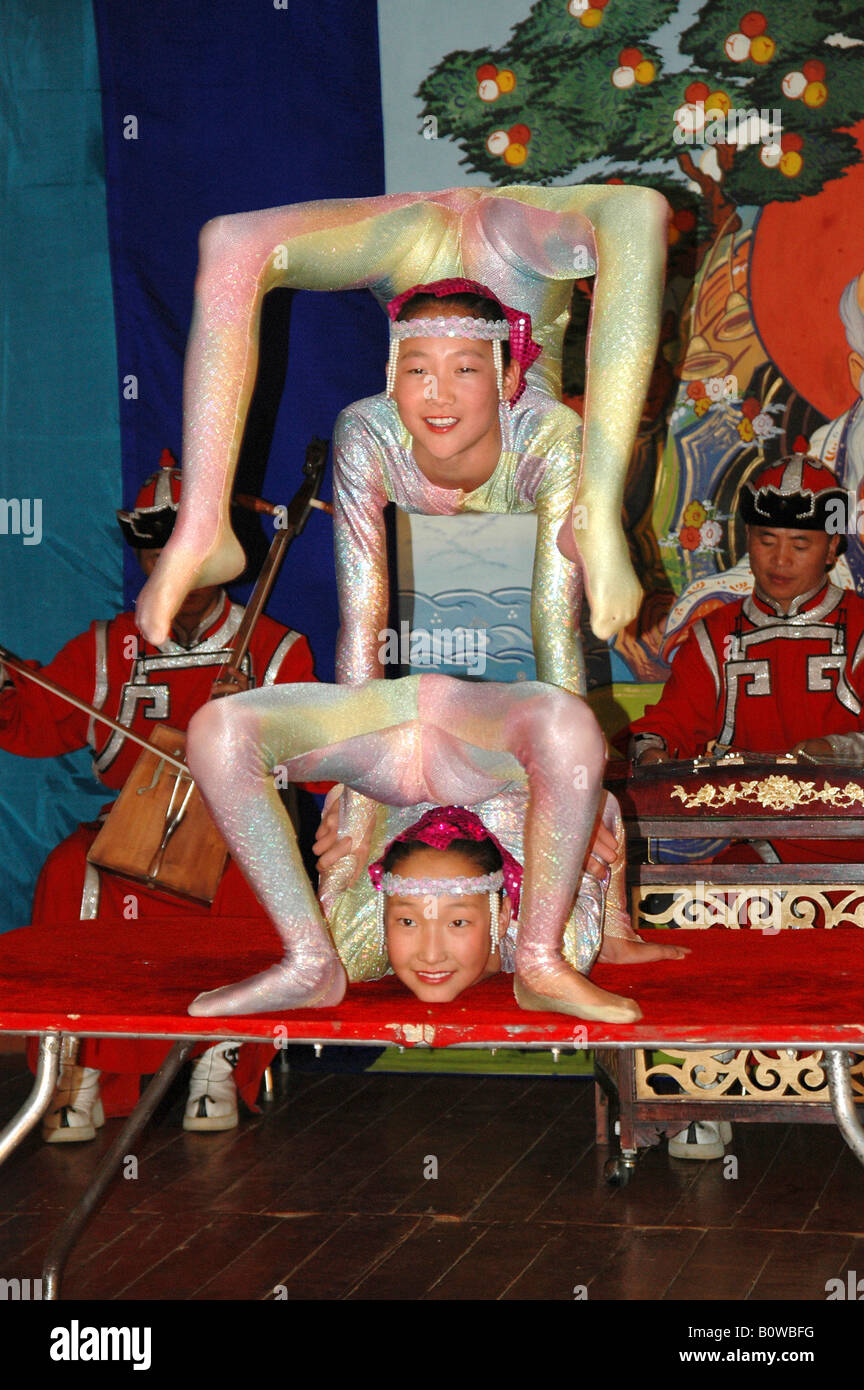 Two snake women contortionists in front of musicians performing at a show, Mongolia, Asia Stock Photo