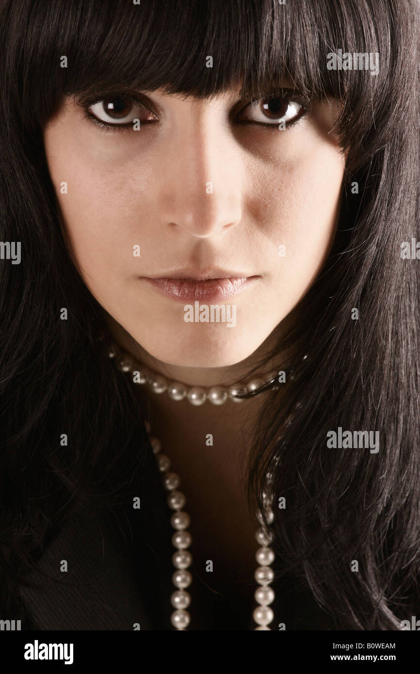 Portrait of a girl with black hair and brown eyes wearing a pearl necklace Stock Photo