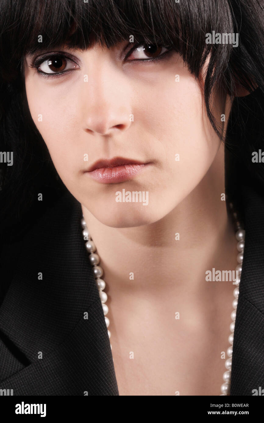 Portrait of a girl with black hair and brown eyes wearing a pearl necklace Stock Photo