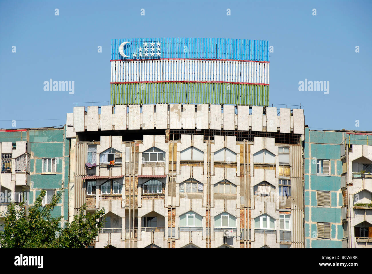 Socialist prefabricated building and Uzbek flag, Tashkent, Uzbekistan, Central Asia Stock Photo