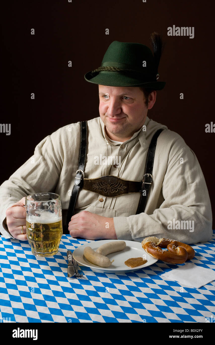 Stereotypical German man in Bavarian costume with a beer and German meal  Stock Photo - Alamy