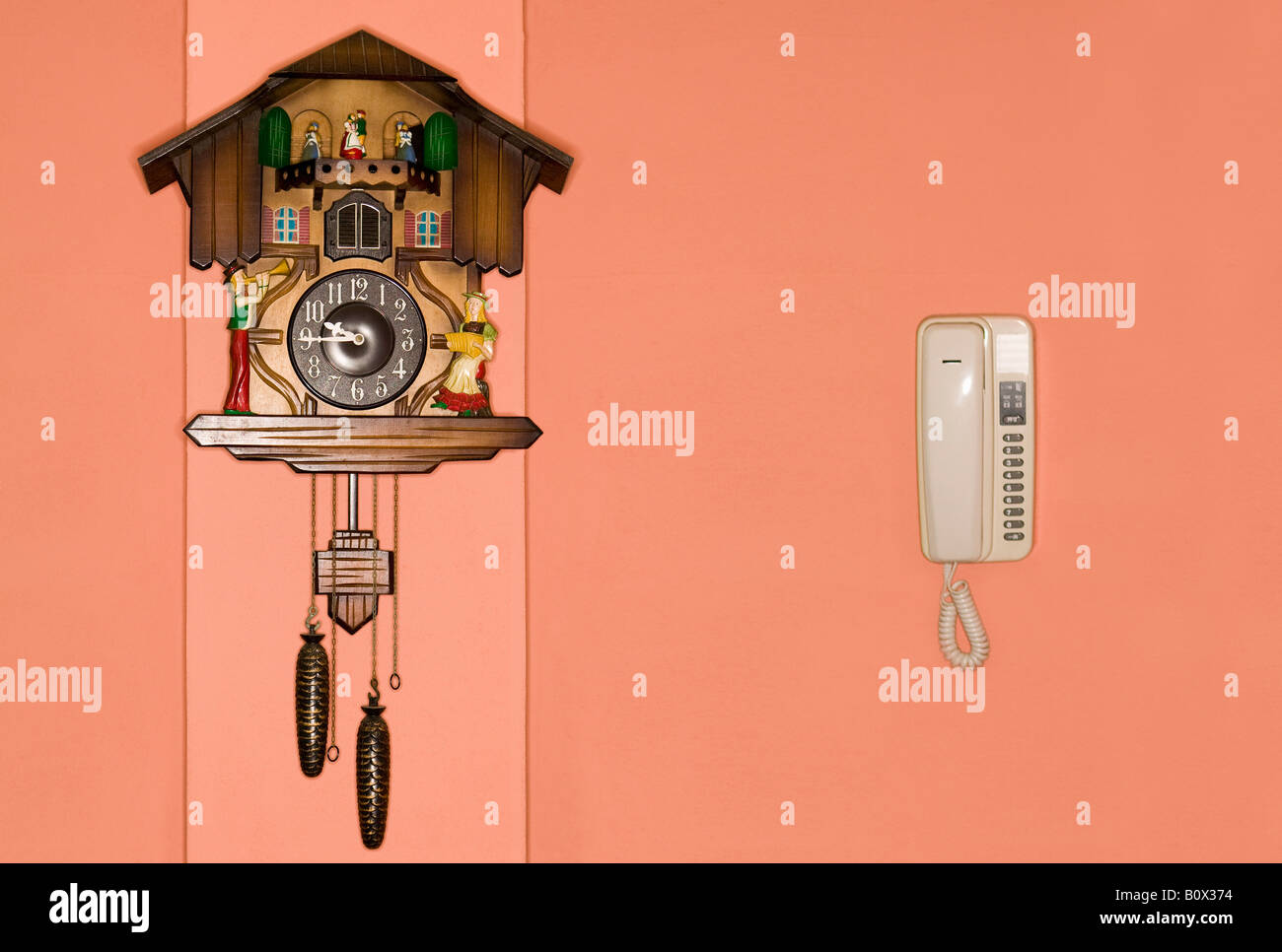 A cuckoo clock and a telephone on a wall Stock Photo Alamy