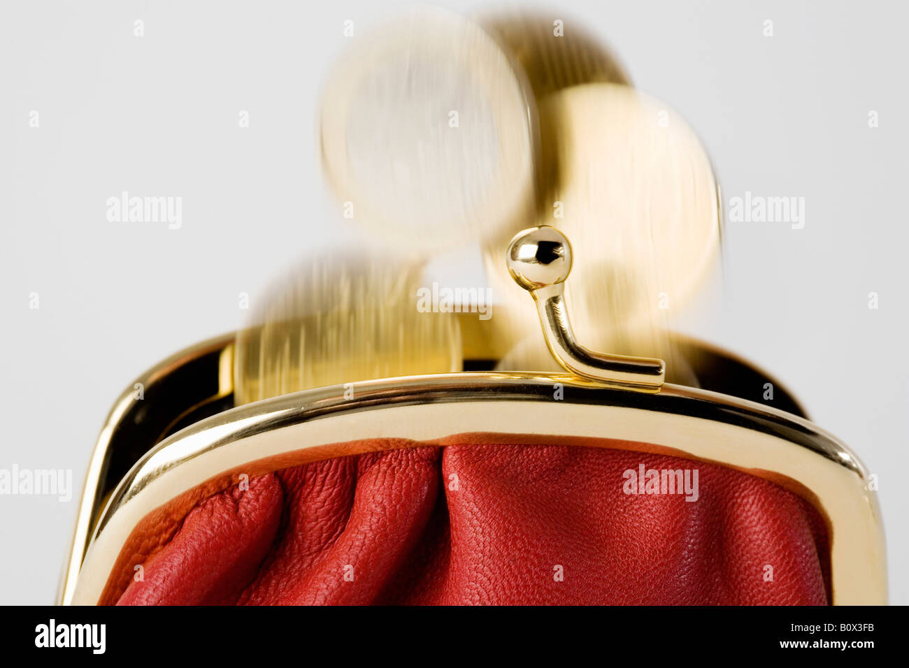 Coins falling into a purse Stock Photo - Alamy