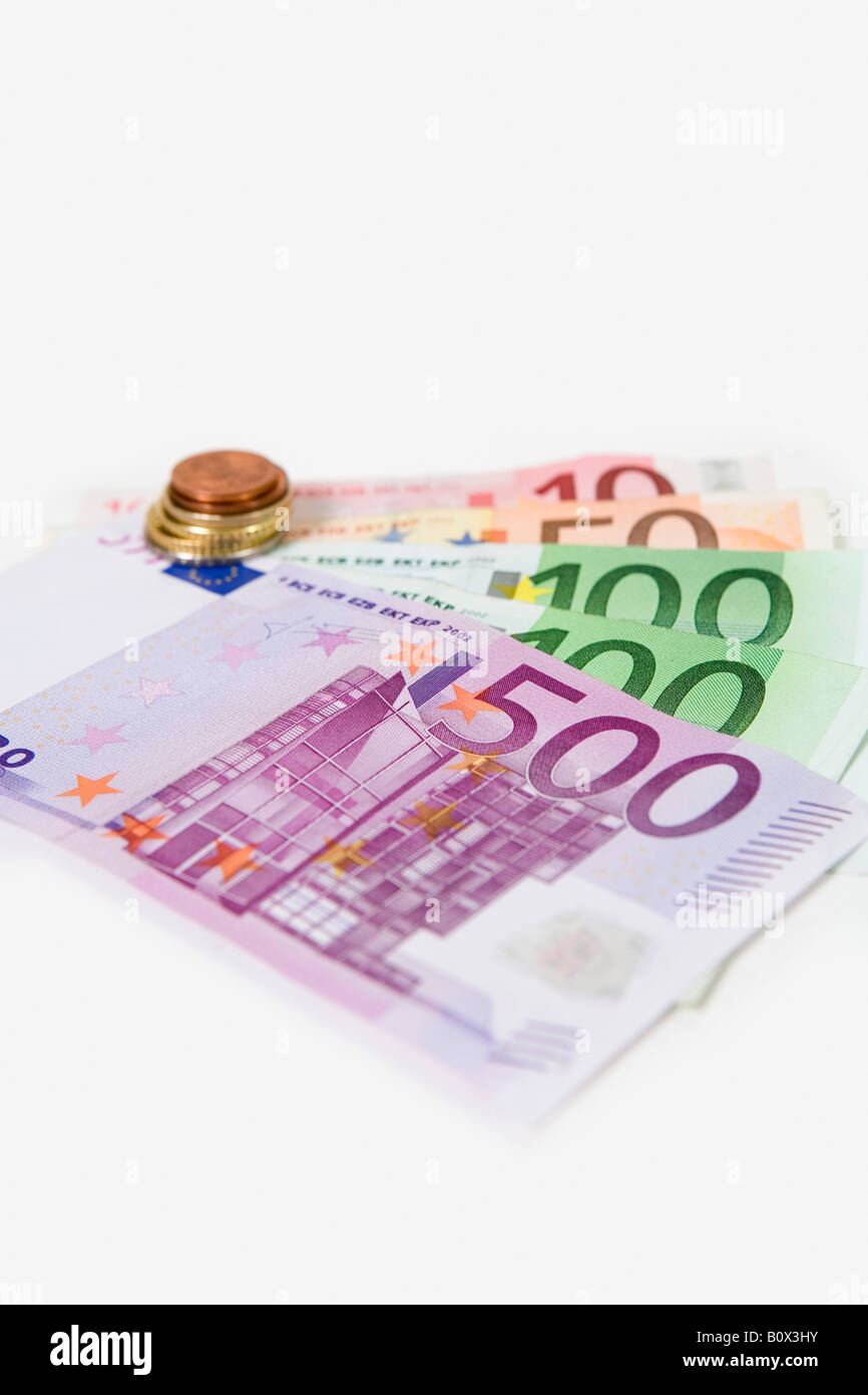 European Currency banknotes fanned out and a stack of European union coins Stock Photo
