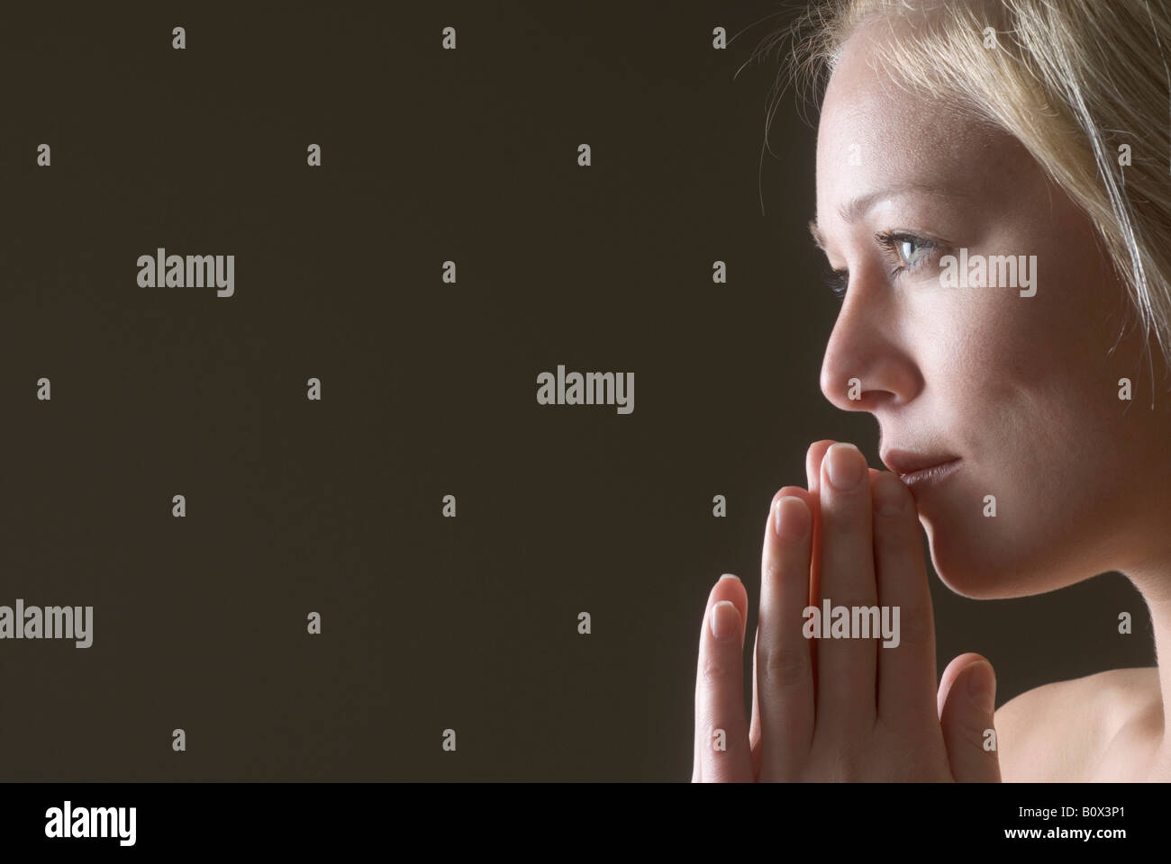 Profile of a woman praying Stock Photo