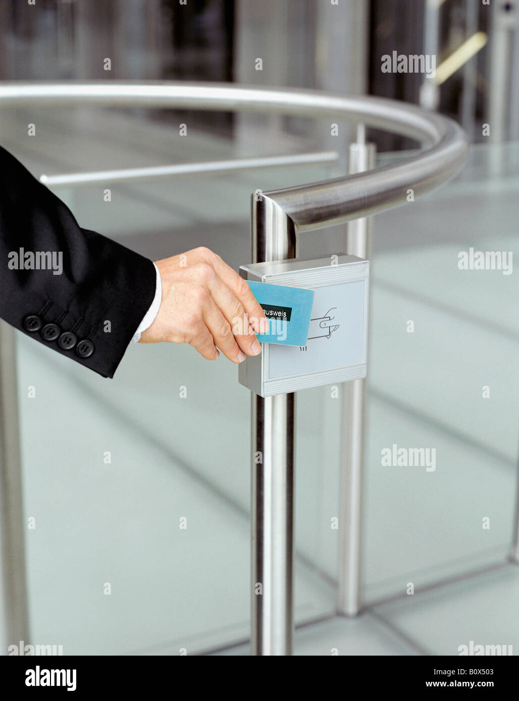 Businessman swiping identification at security gate Stock Photo
