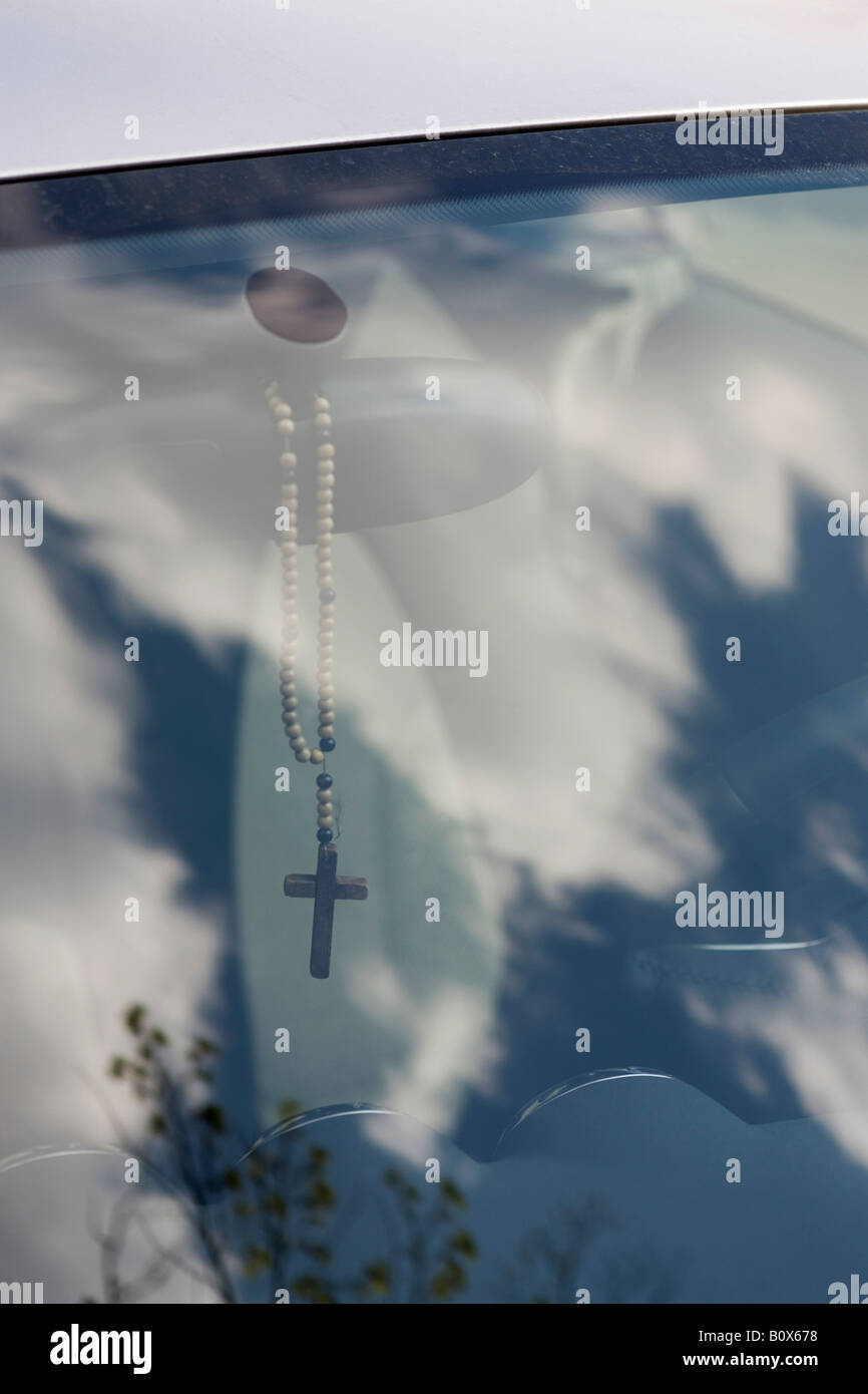 Rosary dangling from rearview mirror, looking through window of car