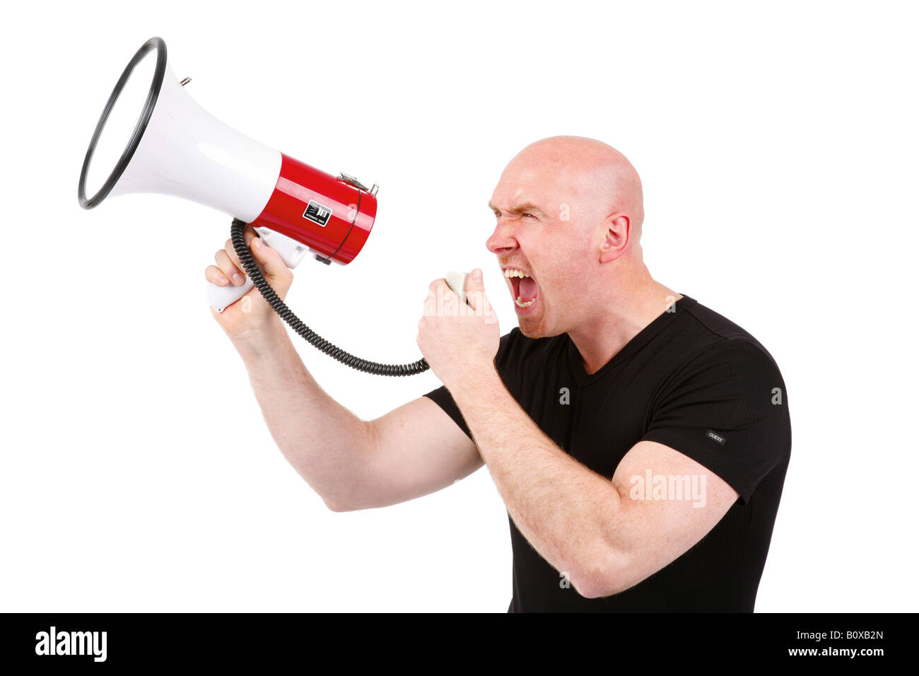 bald headed man roars in a megaphone Stock Photo