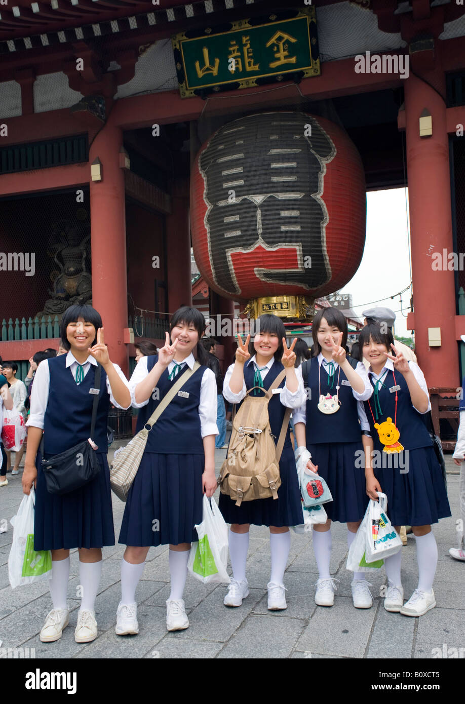 Group of Schoolgirls posing in front of famous entry gate to SensoJi temple in Asakusa in central Tokyo 2008 Stock Photo