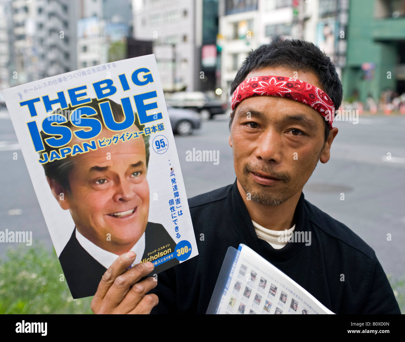 Homeless Japanese man selling copies of The Big Issue in central Tokyo Japan Stock Photo