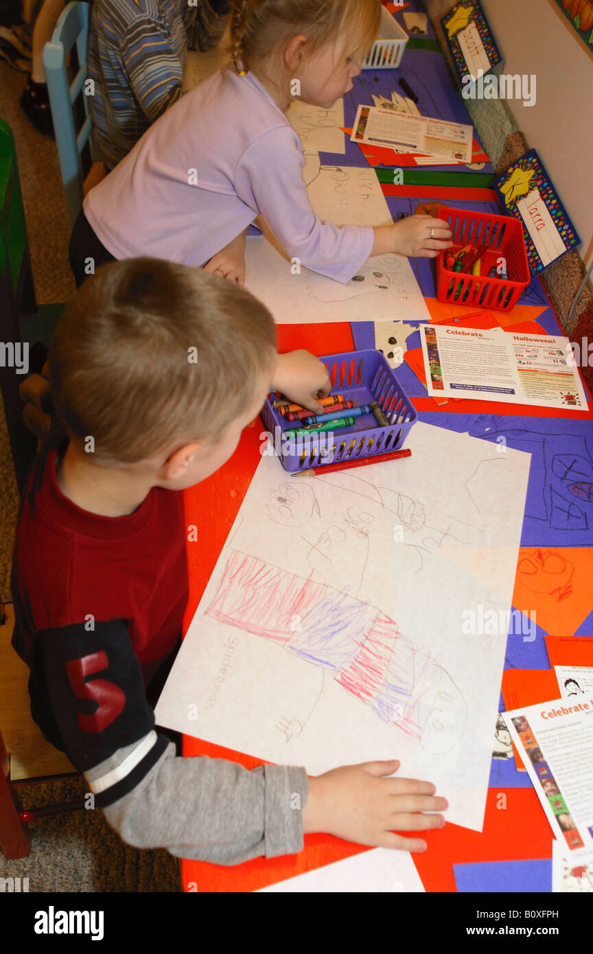 Preschool age children drawing Halloween pictures in class Stock Photo