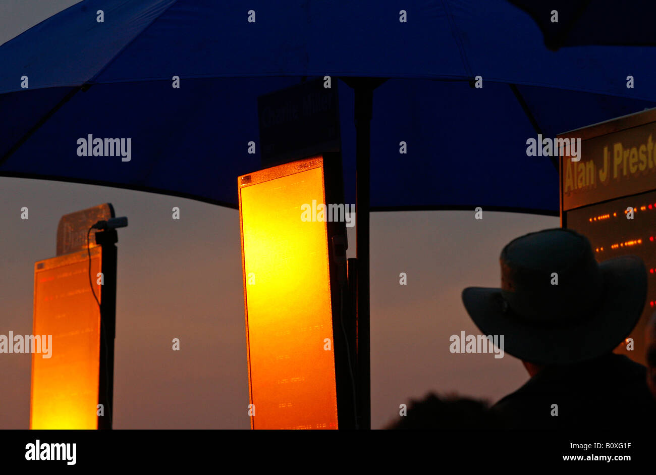 A tote board reflects the last rays of the sun at an evening race meeting at Towcester Racecourse Stock Photo