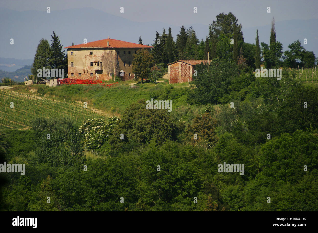 Tuscan landscape with traditional stone building in the distance Stock Photo