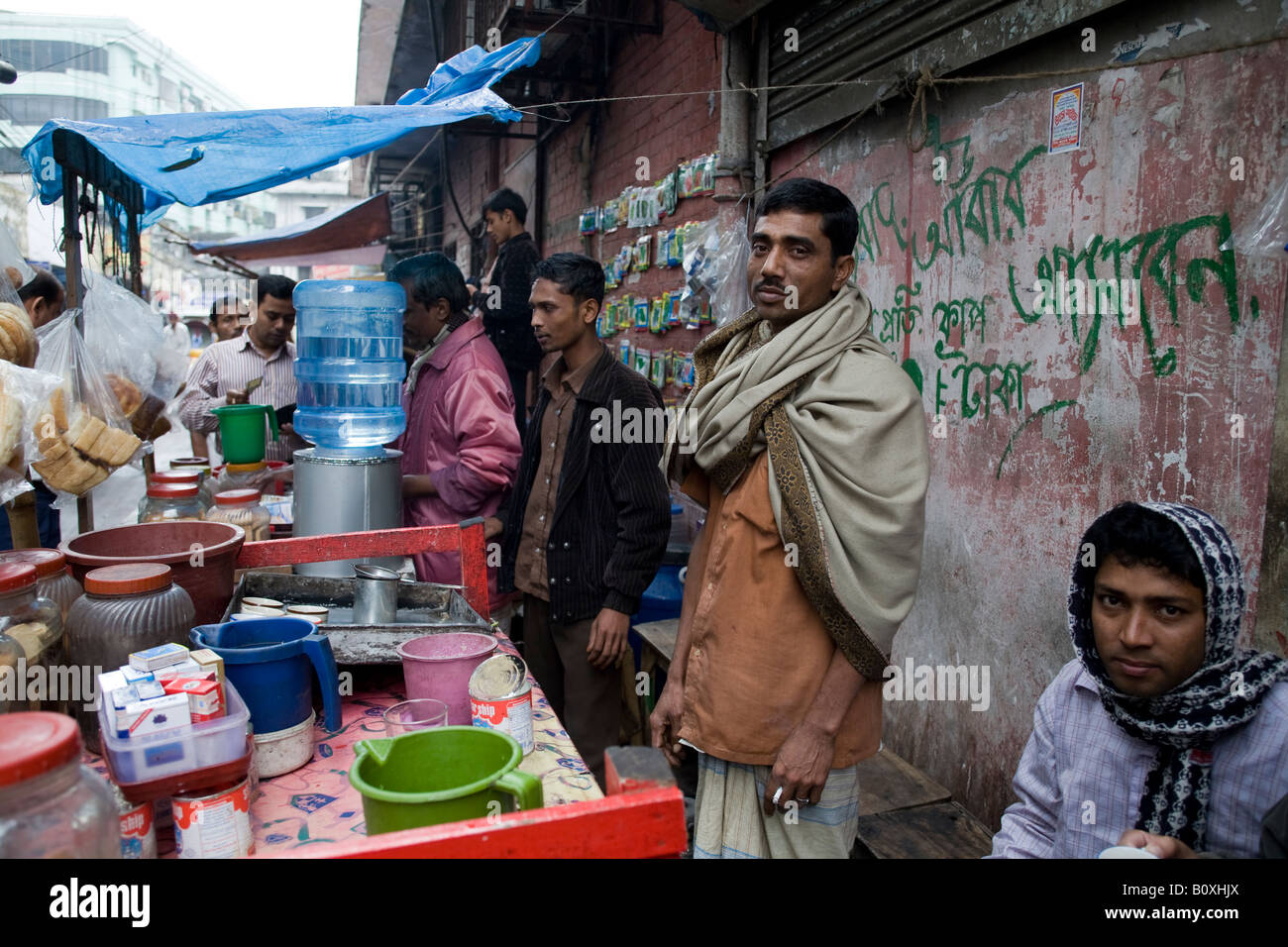 Customers drinking tea from a street vendor in Dhaka Bangladesh Stock