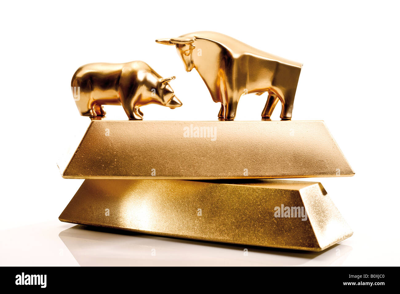 Bull and bear sculptures by gold bars Stock Photo