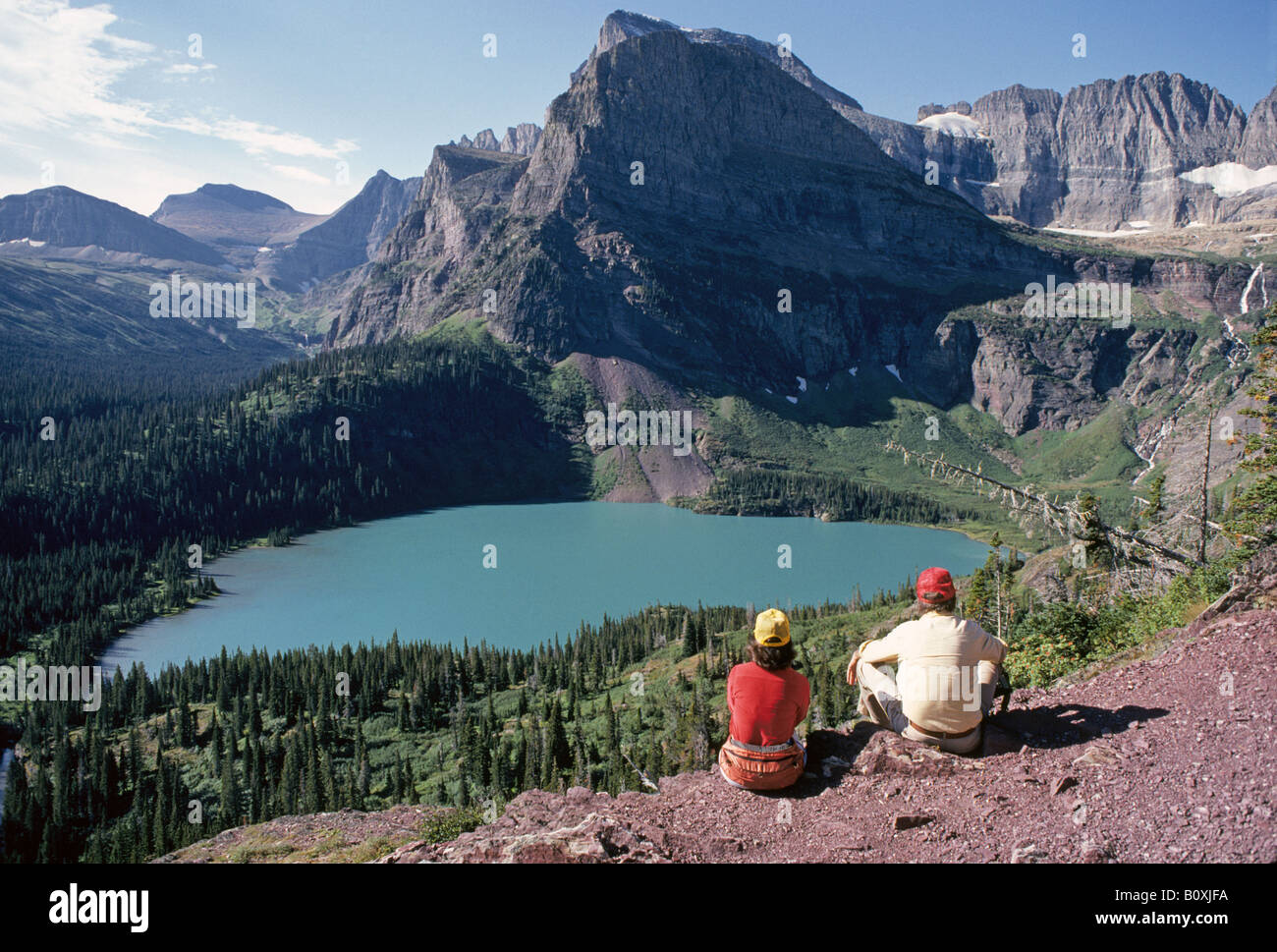 Hikers rest on the Grinnell Glacier trail in Swiftcurrent Valley Stock ...