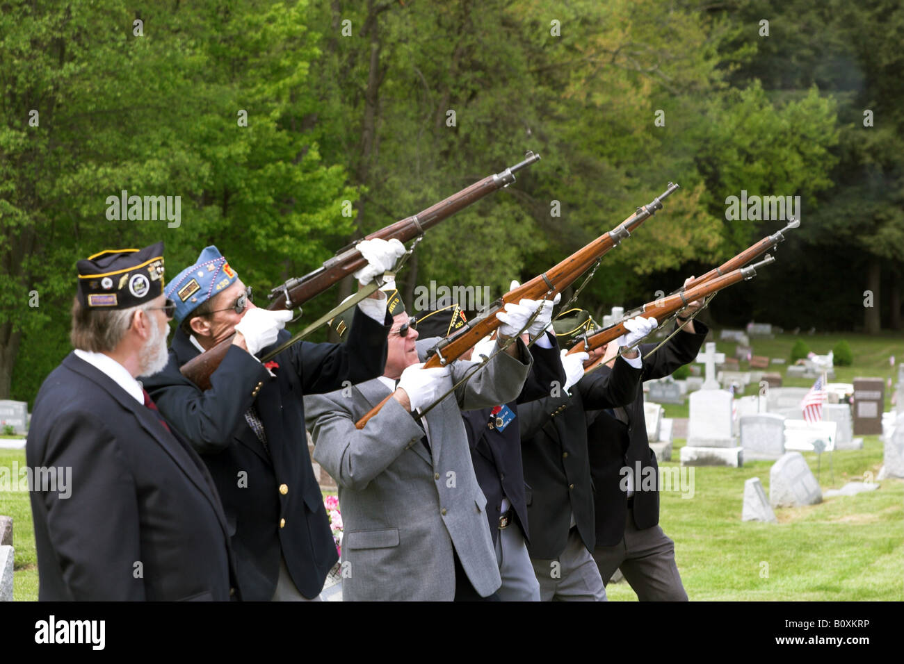 The honor guard performs a gun salute at the funeral of a veteran of